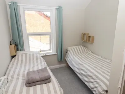 two beds in a room with a window at The Bothy in Lytham St Annes