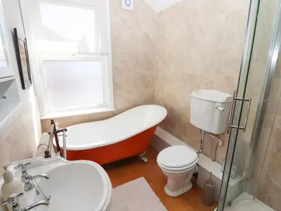 a bathroom with a tub and a toilet and a sink at The Bothy in Lytham St Annes