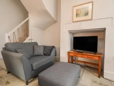 a living room with a couch and a television at The Bothy in Lytham St Annes