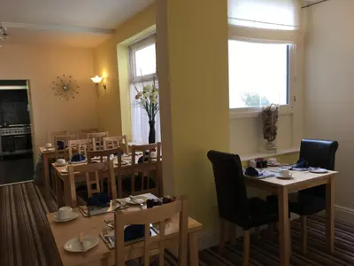 a dining room with tables and chairs and a window at Lyndawn hotel in Blackpool