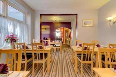a dining room with wooden tables and chairs at Lyndawn hotel in Blackpool
