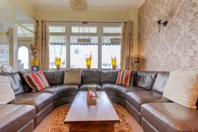 a living room with a leather couch and a coffee table at Lyndawn hotel in Blackpool
