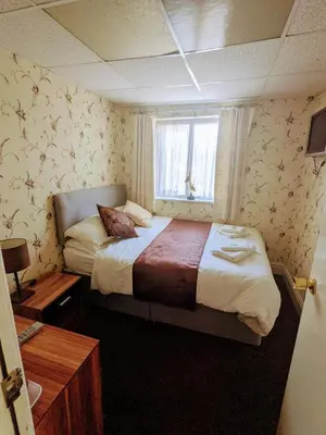 a bedroom with a large bed with a window at Lyndawn hotel in Blackpool