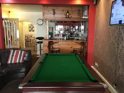a pool table in a room with a bar at Lyndawn hotel in Blackpool