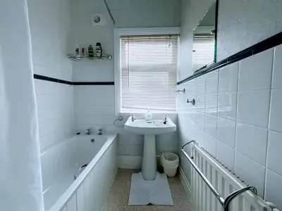 a white bathroom with a sink and a bath tub and a sink at Bare, Morecambe - Parking EV, 2 Bathrooms, 3 King Bedrooms, Good Area in Morecambe