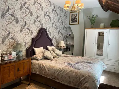 a bedroom with a large bed and a wall at Picket Post House Accommodation in Catterall
