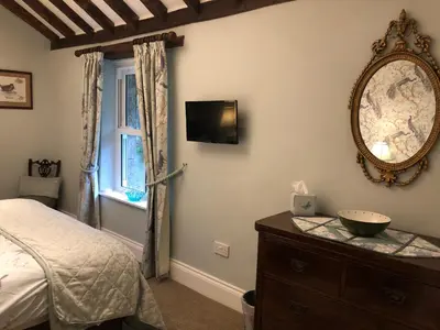 a bedroom with a bed and a mirror and a dresser at Picket Post House Accommodation in Catterall