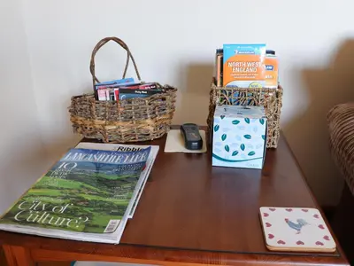a table with books and a basket on top of it at The Proven House in Preston