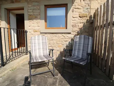 two chairs sitting on a porch next to a window at The Proven House in Preston