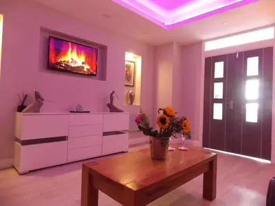 a living room with a table and a fireplace at Eden Suite Sasco Apartments in Blackpool