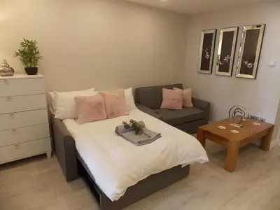 a bedroom with a bed and a couch and a table at Eden Suite Sasco Apartments in Blackpool