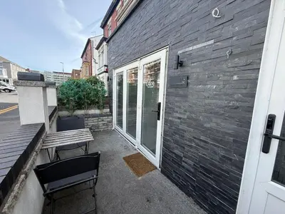 a bench sitting on the side of a building at Eden Suite Sasco Apartments in Blackpool