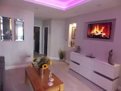 a living room with a fireplace on the wall at Eden Suite Sasco Apartments in Blackpool
