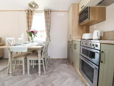a kitchen and dining room with a table and chairs at 25 Sherwood in Carnforth