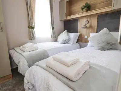 a room with two beds with white towels on them at 25 Sherwood in Carnforth