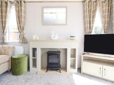 a living room with a fireplace and a tv at 25 Sherwood in Carnforth