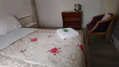 a bedroom with a bed with a blanket with roses on it at Number 36 in Blackpool