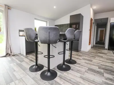 a kitchen with two bar chairs and a counter at Box Tree Escapes in Lancaster