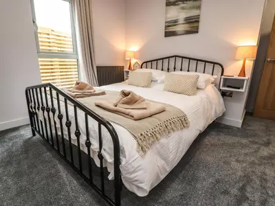 a bedroom with a large bed with white sheets and pillows at Box Tree Escapes in Lancaster