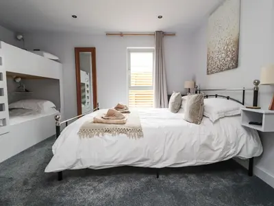 a white bedroom with a large bed and a mirror at Box Tree Escapes in Lancaster
