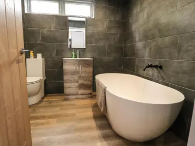 a bathroom with a white tub and a toilet at Box Tree Escapes in Lancaster