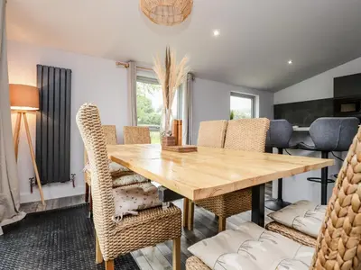 a dining room with a wooden table and chairs at Box Tree Escapes in Lancaster