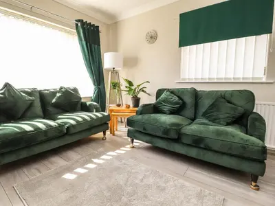 two green leather couches in a living room at 2 Pine Grove in Preston