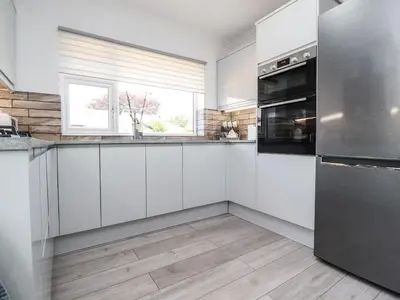 a kitchen with white cabinets and a window at 2 Pine Grove in Preston