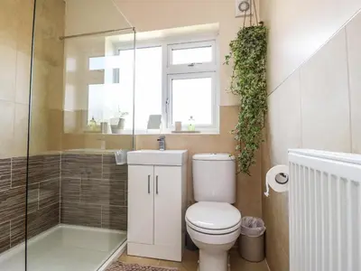 a bathroom with a toilet and a shower and a window at 2 Pine Grove in Preston