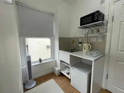 a small white kitchen with a sink and a window at Ariana House Hotel-Families and Couples Only in Blackpool