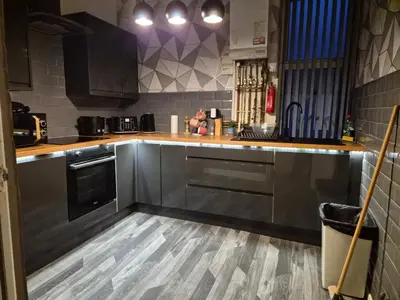 a kitchen with stainless steel appliances and wooden floors at Blackpool Apartments in Blackpool