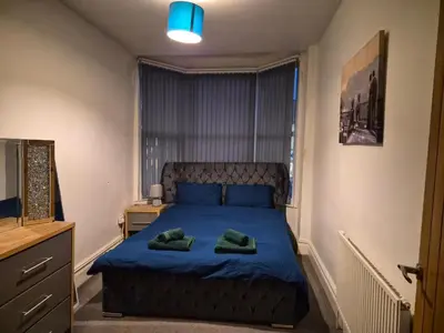 a bedroom with a bed with two green towels on it at Blackpool Apartments in Blackpool