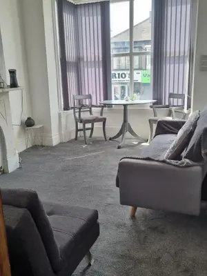 a living room with a couch and a table and chairs at Blackpool Apartments in Blackpool