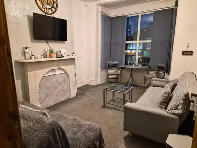 a living room with a fireplace with a tv above it at Blackpool Apartments in Blackpool