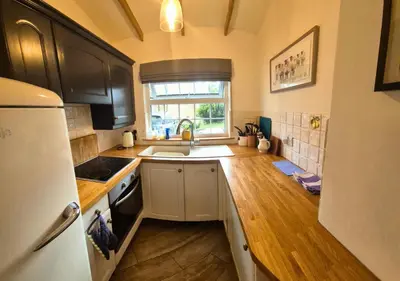 a kitchen with a sink and a refrigerator at Bowland Breaks - Cobble View Cottage with Private Parking Near all the local Wedding Venues in Waddington