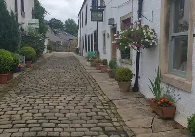 a cobblestone street with potted plants and a building at Bowland Breaks - Cobble View Cottage with Private Parking Near all the local Wedding Venues in Waddington