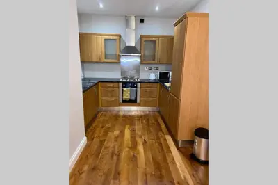 a kitchen with wooden cabinets and a wooden floor at Superb City Centre Location in Liverpool