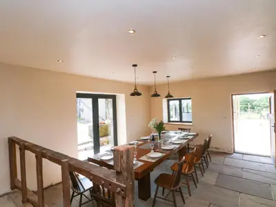 a large dining room with a long table and chairs at Bowland Barn in Lancaster