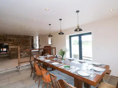a large dining room with a long table and chairs at Bowland Barn in Lancaster
