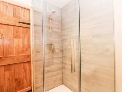 a shower with a glass door in a bathroom at Bowland Barn in Lancaster