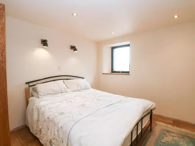 a bedroom with a bed and a window at Bowland Barn in Lancaster