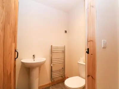 a small bathroom with a toilet and a sink at Bowland Barn in Lancaster
