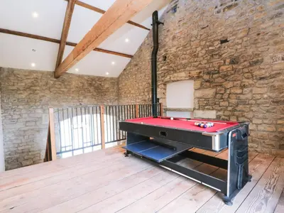a pool table in a room with a brick wall at Bowland Barn in Lancaster