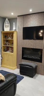 a living room with a fireplace with a large television at Leafy Lytham central Lovely ground floor 1 bedroom apartment with private garden In Lytham dog friendly in Lytham St Annes