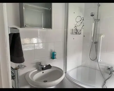 a small bathroom with a shower and a sink at Marley Mansions Clarendon 65 in Wallasey
