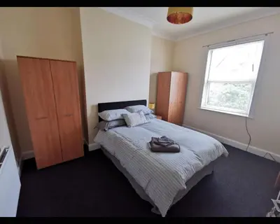 a bedroom with a bed and a large window at Marley Mansions Clarendon 65 in Wallasey