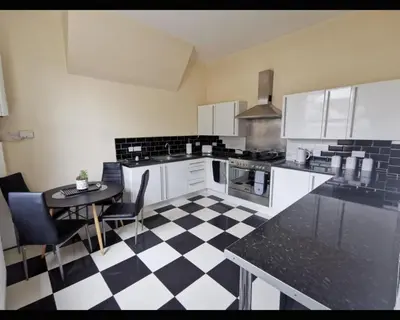 a kitchen with a black and white checkered floor at Marley Mansions Clarendon 65 in Wallasey