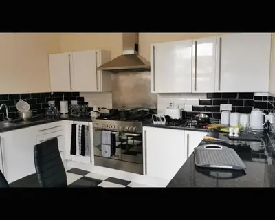 a kitchen with white cabinets and a stove top oven at Marley Mansions Clarendon 65 in Wallasey