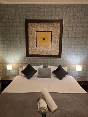 a bedroom with a bed with two lamps and a painting on the wall at The Rockley Hotel in Blackpool
