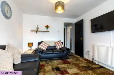 a living room with a leather couch and a clock at St Luke's 2 in Liverpool